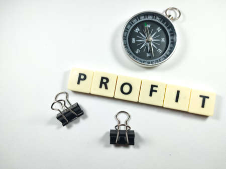 Selective focus. letters with text PROFIT with compass and paper clips on white background.の写真素材