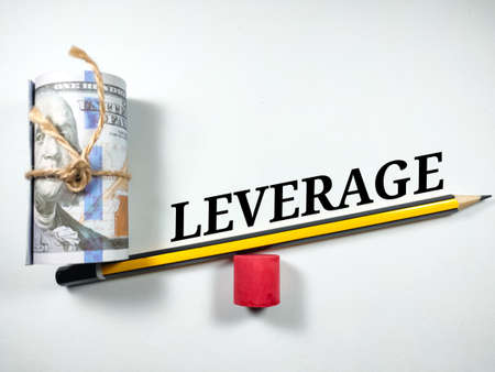 Business concept. Text LEVERAGE with dollar banknote and pencil on white background.の写真素材