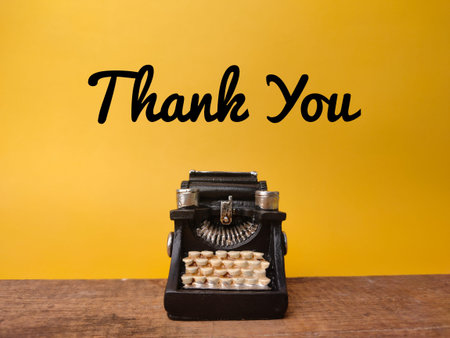 Vintage black typewriter with text Thank You on the wooden background.