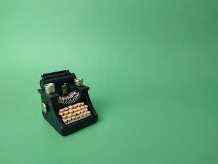 Vintage black typewriter on the green background, copy space for your textの写真素材