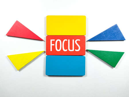 Colorful wooden board with text FOCUS on white background.の写真素材
