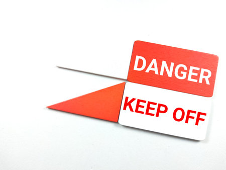 Colorful wooden board with text DANGER KEEP OFF on white background.