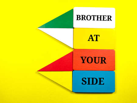 Colorful wooden board with text BROTHER AT YOUR SIDE on yellow background.の写真素材