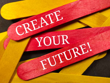 Text CREATE YOUR FUTURE on colorful wooden stick with wooden stick and black background.の写真素材