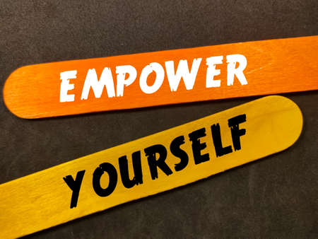 Text EMPOWER YOURSELF with colorful wooden stick on black background.の写真素材