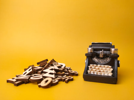 Wooden word and vintage black typewriter on the yellow background.の写真素材