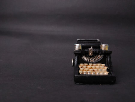 Vintage black typewriter on the black background, copy space for your text.の写真素材
