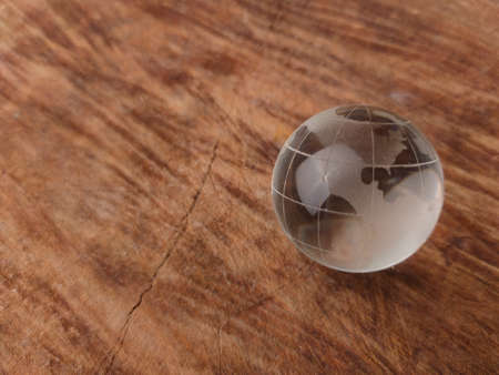 Crystal earth globe on a wooden background with copy space.の写真素材