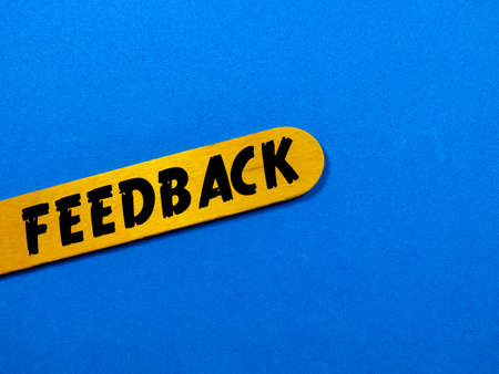 Business concept.Text FEEDBACK writing on colored ice cream stick on a blue background.の写真素材
