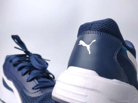 Malaysia, 25 March 2022: Puma blue shoes on a white background. Puma is the third largestÂ sportswearÂ manufacturer in the worldのeditorial素材