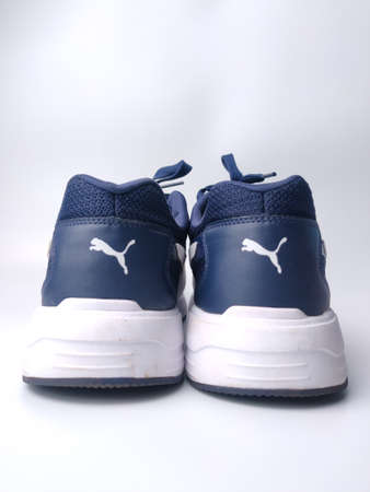 Malaysia, 25 March 2022: Puma blue shoes on a white background. Puma is the third largestÂ sportswearÂ manufacturer in the worldのeditorial素材