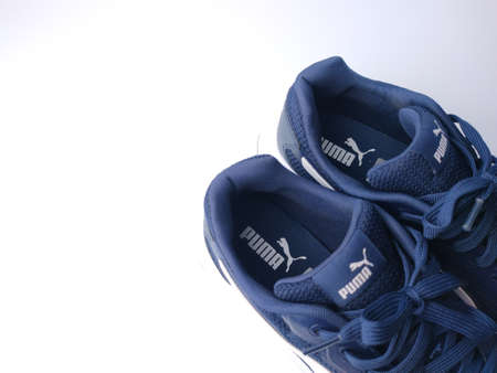 Malaysia, 25 March 2022: Puma blue shoes on a white background. Puma is the third largestÂ sportswearÂ manufacturer in the worldのeditorial素材