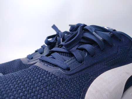 Malaysia, 25 March 2022: Puma blue shoes on a white background. Puma is the third largestÂ sportswearÂ manufacturer in the worldのeditorial素材