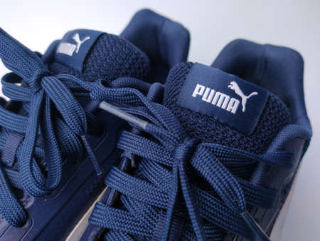 Malaysia, 25 March 2022: Puma blue shoes on a white background. Puma is the third largestÂ sportswearÂ manufacturer in the worldのeditorial素材