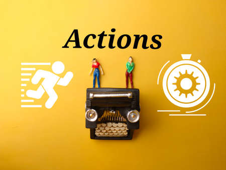 Miniature people,typewritter and icon with text Actions on yellow background.の写真素材