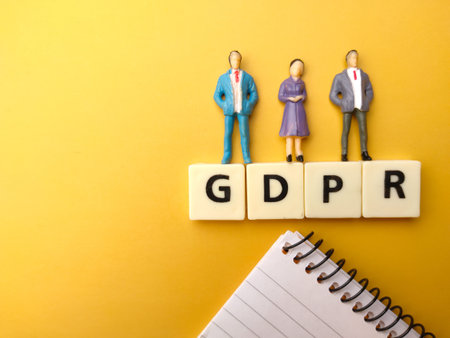 Miniature people,notebook and toys word with text GDPR on yellow background.の写真素材