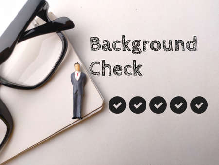 Miniature people,glasses and icon with text Background Check on white background.の写真素材