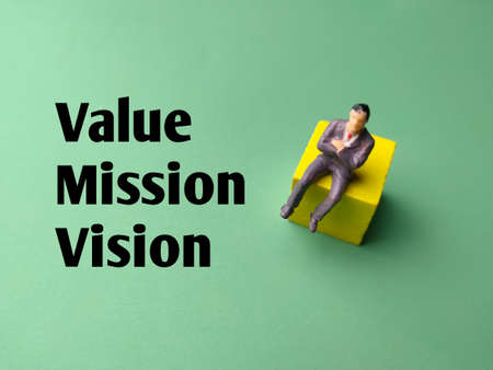 Miniature people with text Value Mission vision on a green background.の写真素材