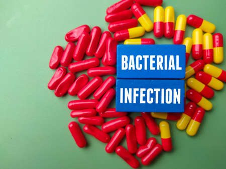 Top view medical pill with text BACTERIAL INFECTION on a green background.の写真素材