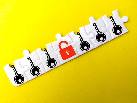A white puzzle with a key and lock icon with an open red lock. the concept of safetyの写真素材