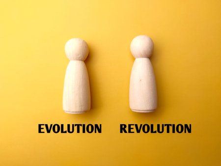 Wooden figures with the word EVOLUTION REVOLUTION on a yellow background.