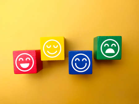 Colored wooden block with happy and unhappy expression. Positive and negative concept.の写真素材