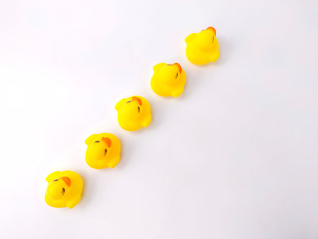 A group of toy ducks arranged straight on a white backgroundの写真素材