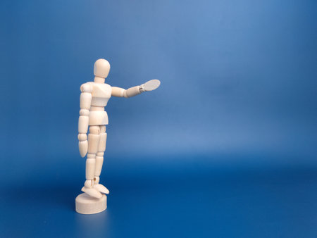 Wooden mannequin with action on a blue background with copy space.の写真素材