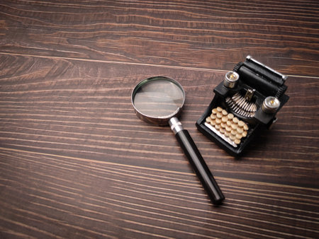 Vintage black typewritter  and magnifying glass on a wooden background.の写真素材