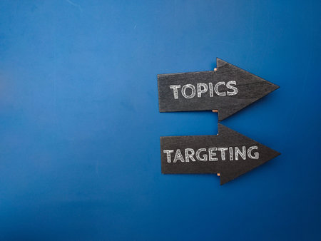 Arrow wooden board with the word TOPICS TARGETING on a blue background.