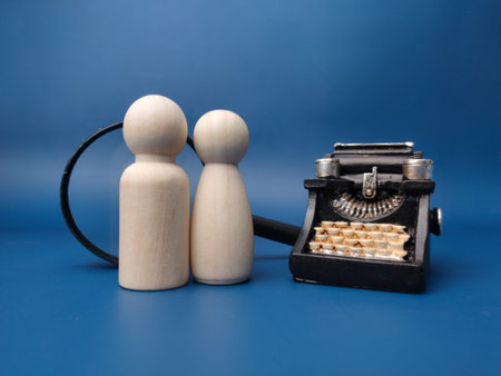 Vintage type writter,peg doll and magnifying glass on a blue background.
