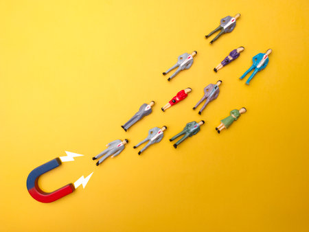 Businessman attracts by magnet on a yellow background. Business and leadership concept.の写真素材