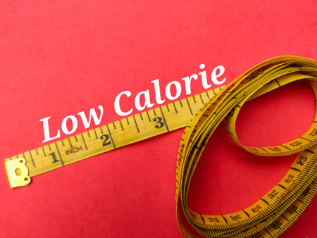 Yellow measuring tape with the word Low Calorie on a red backgroundの写真素材