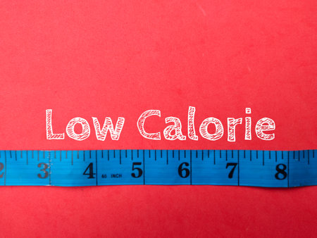 Blue measuring tape with the word Low Calorie on a red backgroundの写真素材