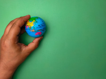 Hand holding earth globe on a green background.Nature and earth concept.の写真素材