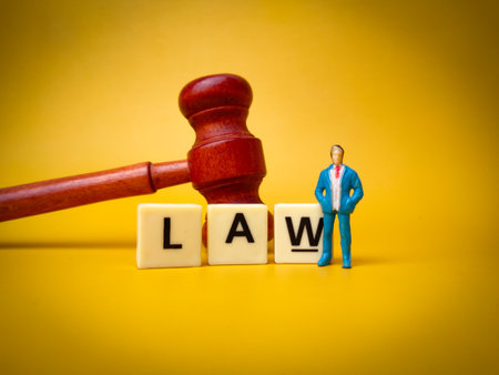 Gavel,toys word and miniature people with the word LAW on a yellow background.の写真素材