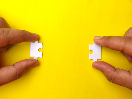 Hand holding white on a yellow background with copy space.の写真素材