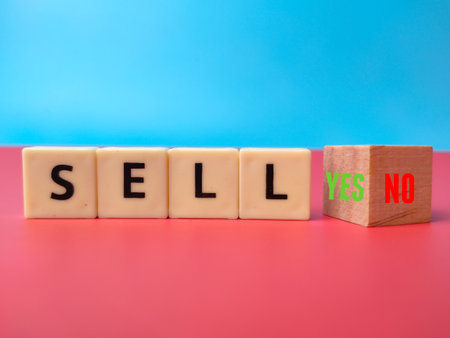 Toys word and wooden cube with word SELL YES NO on blue background. Business concept.の写真素材
