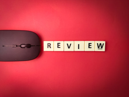 Toys word and wireless mouse with the word REVIEW on red background.Business concept.の写真素材