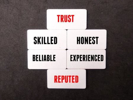 Wooden board with word TRUST,SKILLED,HONEST,BELIABLE,EXPERIENCED on black background.の写真素材