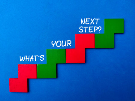 Colored wooden ladder with text WHAT YOUR NEXT STEP? on blue background. Business concept.の写真素材