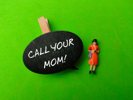 Wooden sign board with the word CALL YOUR MOM on green backgroundの写真素材