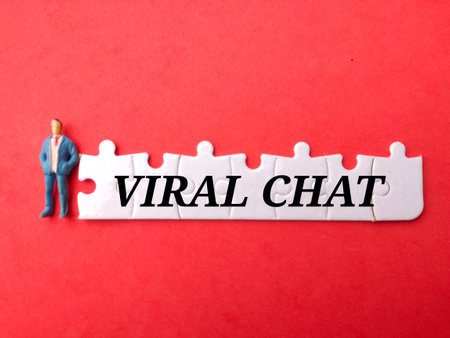 Miniature people and white puzzle with the word VIRAL CHAT on a red background.の写真素材