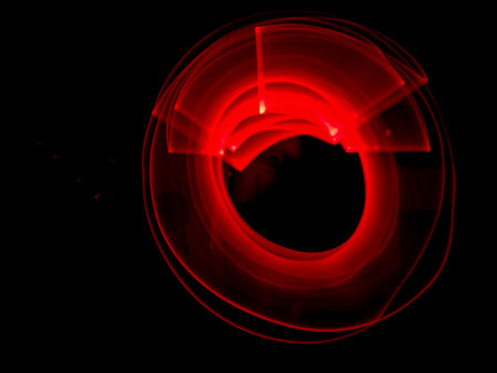 Red light painting, long exposure photography, ripples and round pattern with black background.