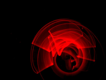 Red light painting, long exposure photography, ripples and round pattern with black background.