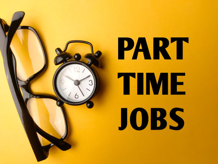 Glasses and clock with the word PART TIME JOBS on yellow backgroundの写真素材