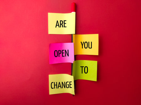 Pencil and sticky note with the word ARE YOU OPEN TO CHANGE on a red backgroundの写真素材
