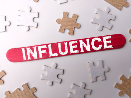 Colored wooden stick and puzzle with the word INFLUENCE on a white backgroundの写真素材