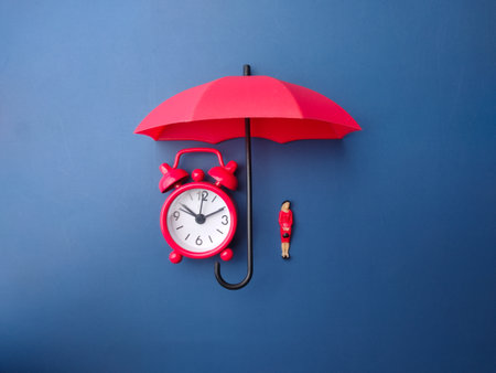 Red umbrella,clock and miniature people on a blue backgroundの写真素材