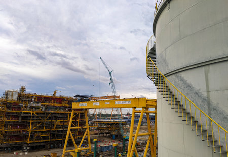 Oil storage tanks in an industrial area with the background of the oil rig construction process.の写真素材